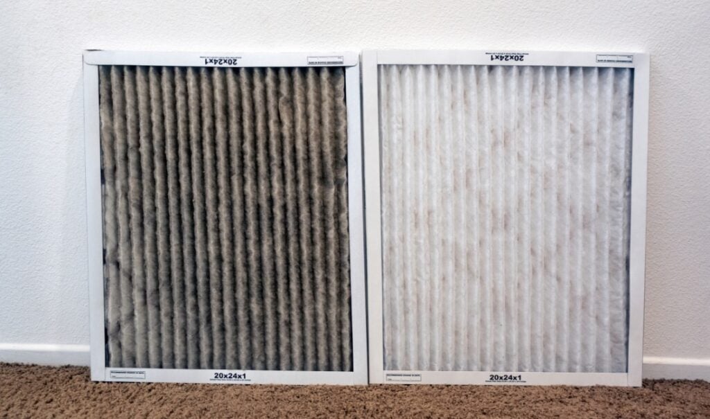 Dirty air filter next to a clean air filter on carpeted floor.